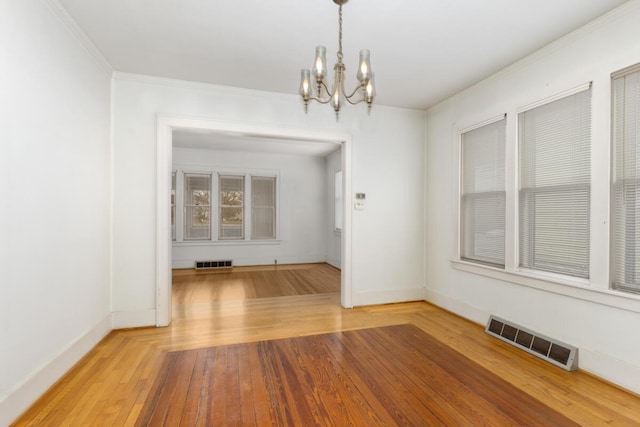 unfurnished dining area with a chandelier, wood-type flooring, and visible vents