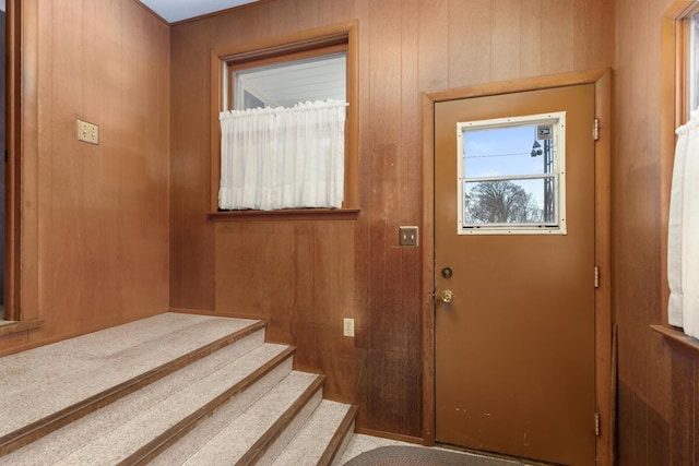 entryway with wood walls and stairway