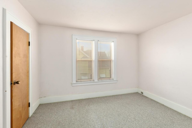 unfurnished room featuring carpet and baseboards