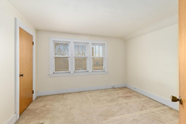 unfurnished room with light carpet and baseboards