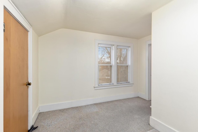 bonus room with lofted ceiling, light colored carpet, and baseboards