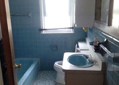 full bath featuring a washtub, tile walls, toilet, a sink, and walk in shower