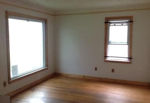 spare room with light wood finished floors and baseboards