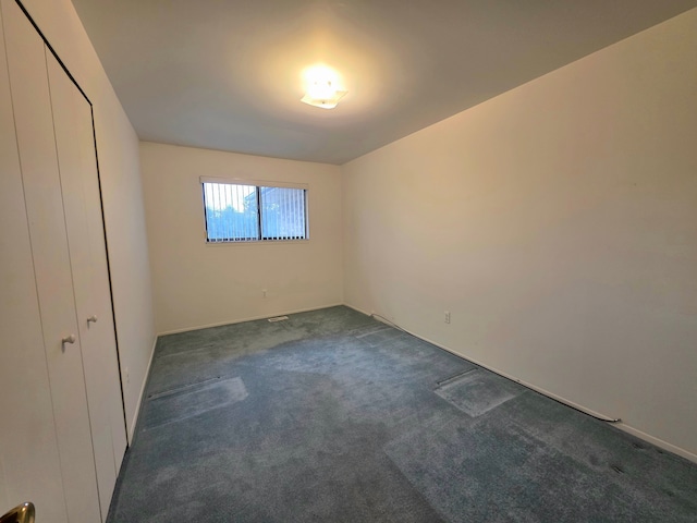 unfurnished bedroom featuring dark carpet