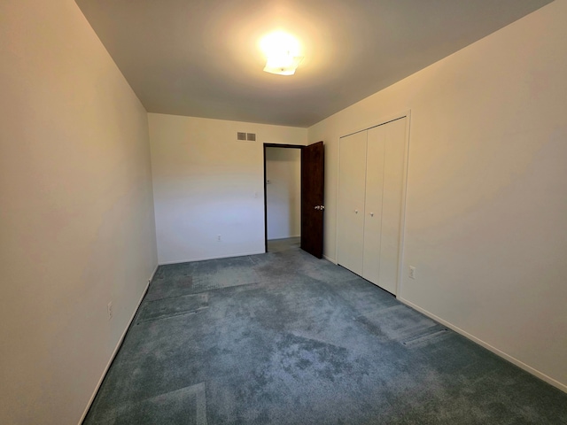 unfurnished bedroom with a closet, visible vents, and carpet flooring