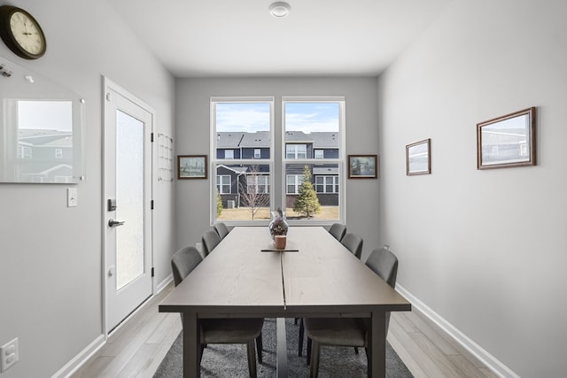 dining room featuring light wood-style floors and baseboards