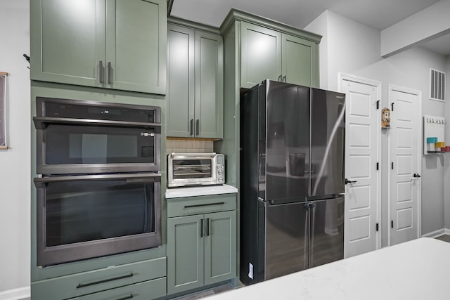 kitchen featuring green cabinetry, visible vents, appliances with stainless steel finishes, and a toaster