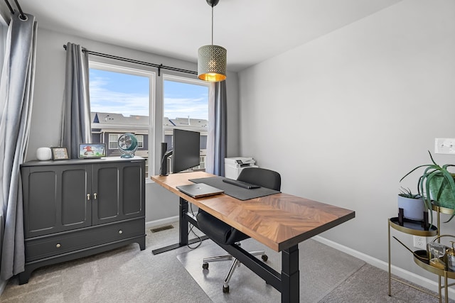 office featuring visible vents, light colored carpet, and baseboards