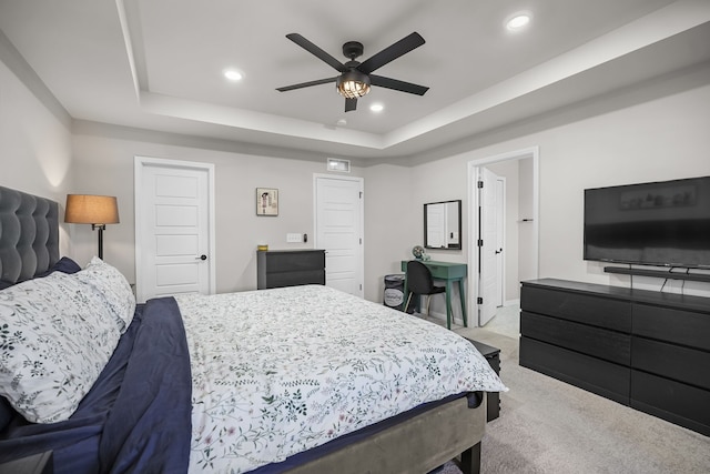 carpeted bedroom featuring recessed lighting, a raised ceiling, and a ceiling fan