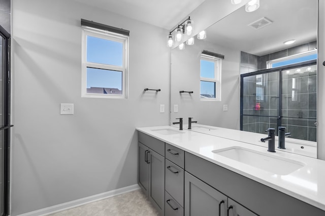 bathroom with tiled shower, visible vents, and a sink