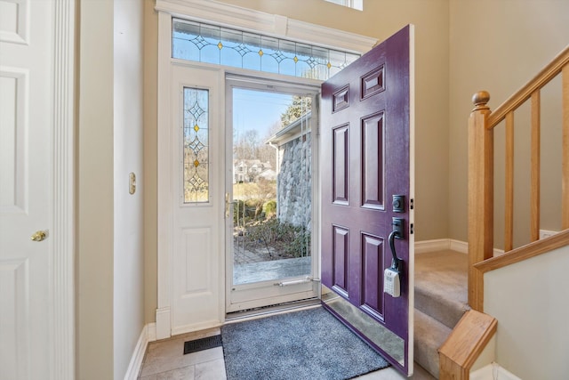 foyer featuring stairs, baseboards, and visible vents