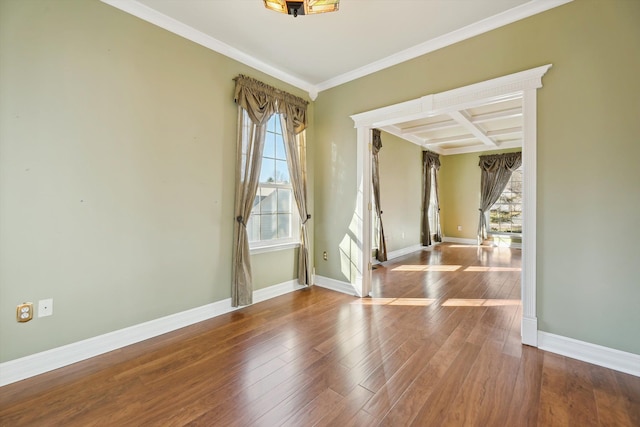 spare room featuring plenty of natural light, wood finished floors, baseboards, and coffered ceiling