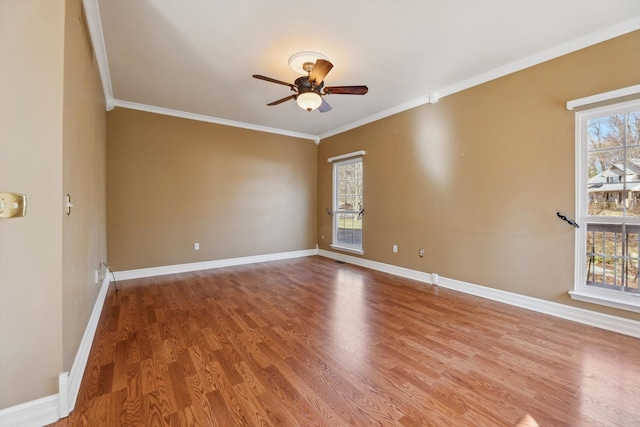 unfurnished room with plenty of natural light, baseboards, and ornamental molding