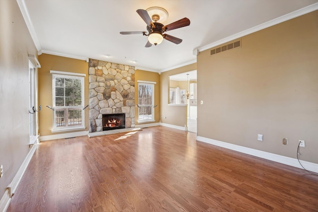 unfurnished living room featuring visible vents, a healthy amount of sunlight, a fireplace, and wood finished floors