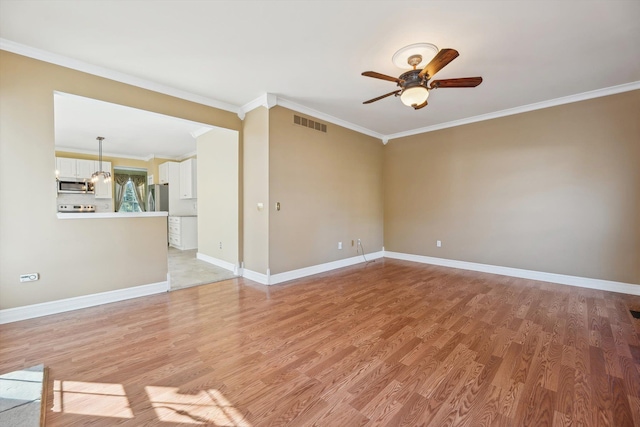 spare room featuring light wood-type flooring, visible vents, ornamental molding, baseboards, and ceiling fan