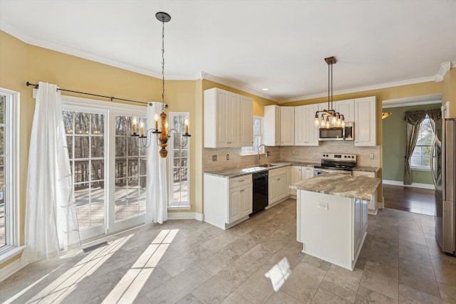 kitchen with a sink, decorative backsplash, appliances with stainless steel finishes, and a chandelier