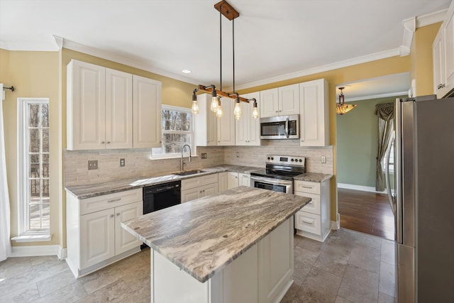 kitchen featuring light stone counters, decorative backsplash, appliances with stainless steel finishes, crown molding, and a center island