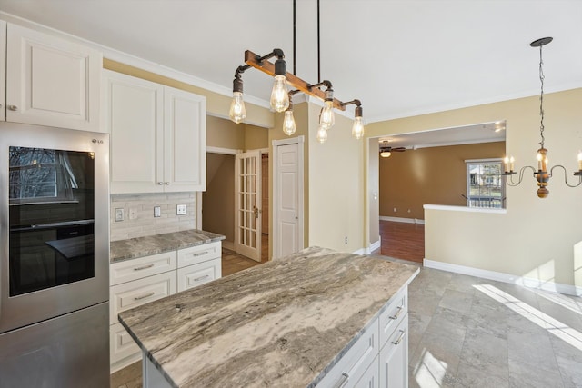 kitchen with light stone counters, decorative backsplash, baseboards, and white cabinetry