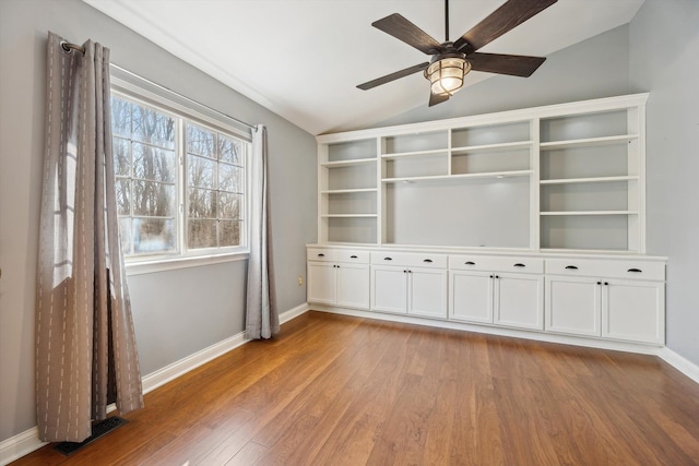 interior space featuring visible vents, light wood finished floors, baseboards, ceiling fan, and vaulted ceiling