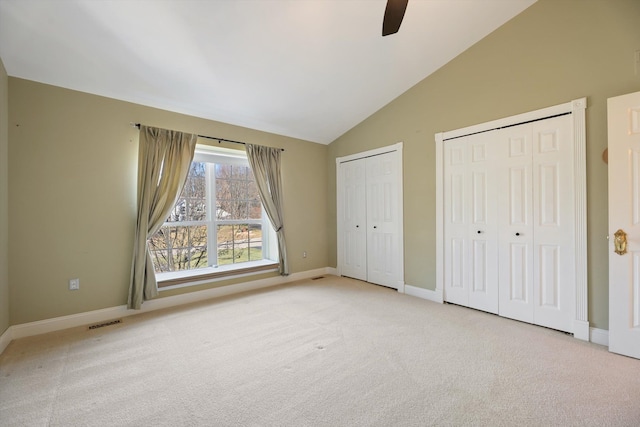 unfurnished bedroom featuring a ceiling fan, baseboards, visible vents, carpet floors, and multiple closets