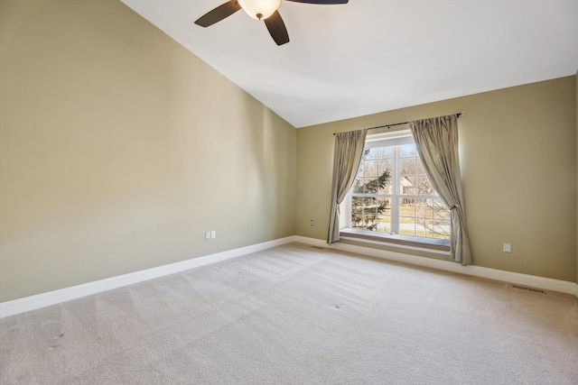 spare room with lofted ceiling, baseboards, visible vents, and light carpet