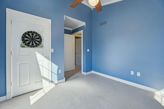 unfurnished bedroom with baseboards, visible vents, carpet floors, and ornamental molding