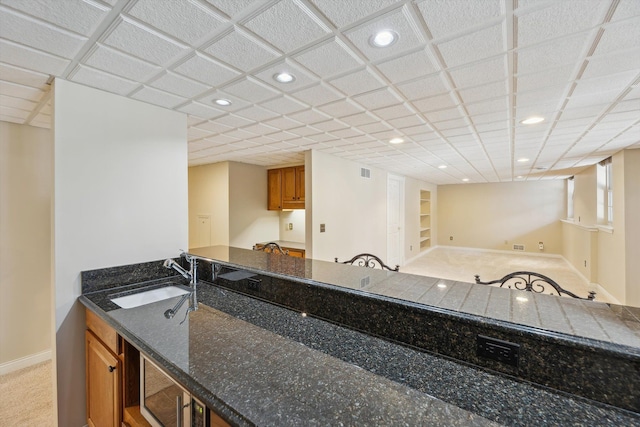 kitchen featuring a sink, brown cabinets, built in features, and recessed lighting