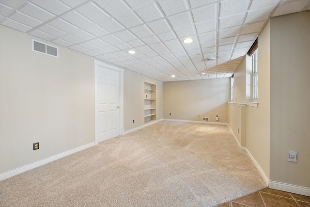 basement featuring visible vents, built in features, recessed lighting, carpet floors, and baseboards