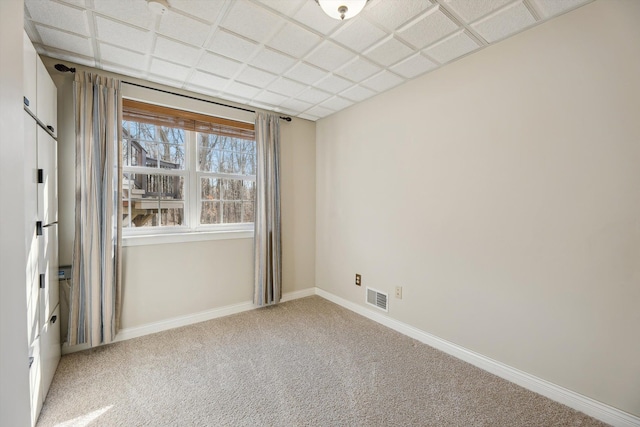 spare room featuring baseboards, visible vents, and carpet floors