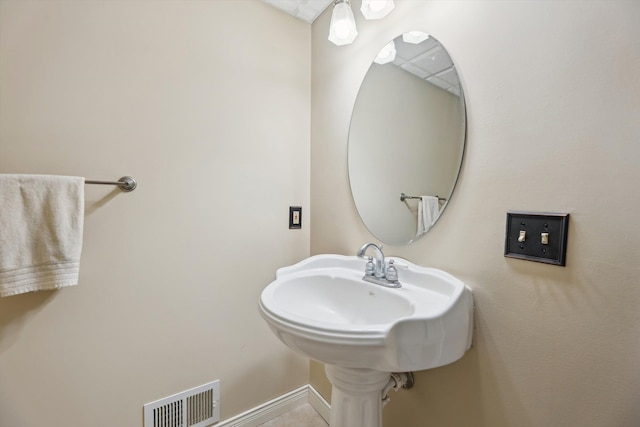 bathroom with a sink, visible vents, and baseboards