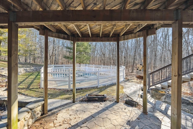 view of patio / terrace with a pool and fence