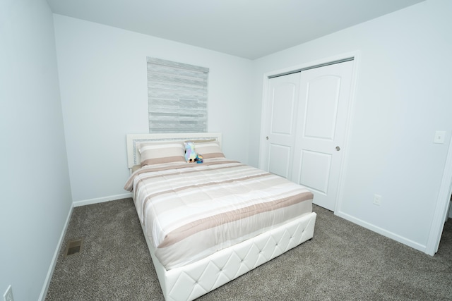 bedroom featuring a closet, carpet flooring, visible vents, and baseboards