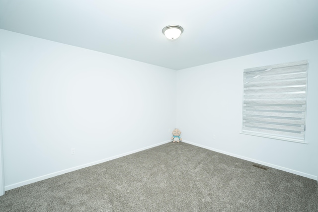 carpeted spare room featuring baseboards