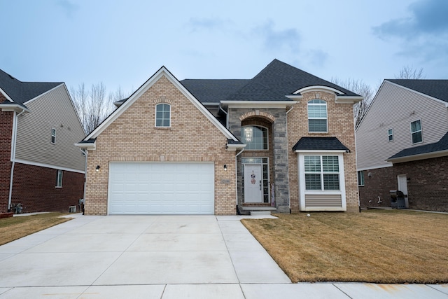 view of front facade with driveway, brick siding, a front lawn, and a shingled roof