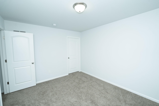 unfurnished bedroom with carpet floors, visible vents, and baseboards