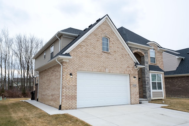 view of front of home featuring an attached garage, a front lawn, concrete driveway, and brick siding