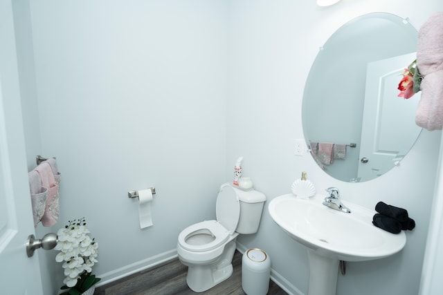 bathroom with a sink, wood finished floors, toilet, and baseboards