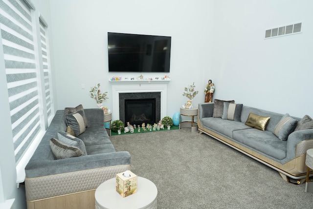 carpeted living area with a fireplace and visible vents