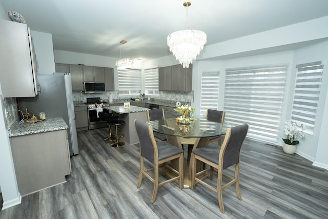 dining area with baseboards, a chandelier, and dark wood-type flooring