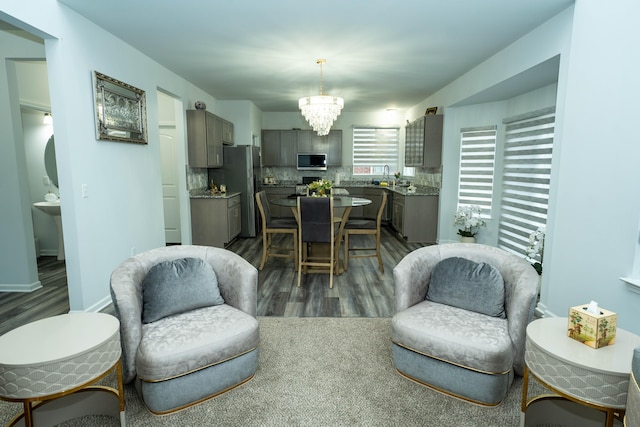 dining area featuring baseboards, dark wood-style flooring, and a notable chandelier