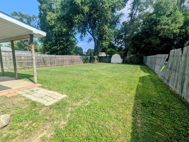 view of yard with an outbuilding, a shed, and a fenced backyard