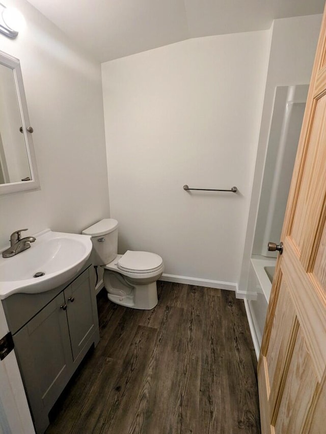 full bathroom with baseboards, vanity, toilet, and wood finished floors