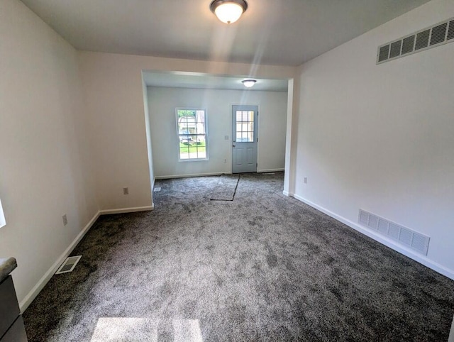 spare room featuring baseboards, visible vents, and carpet flooring