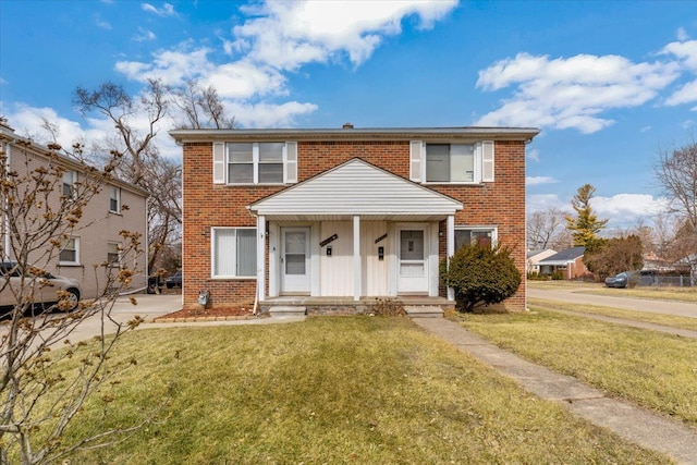 view of front of house with brick siding and a front lawn