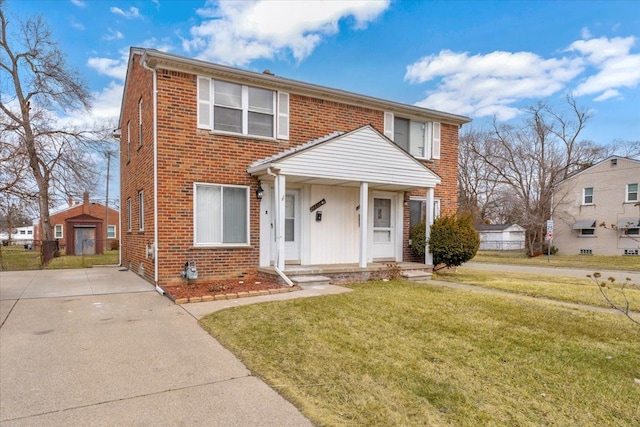 view of front of home featuring brick siding and a front lawn