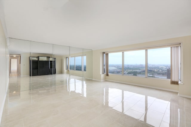 unfurnished living room with a view of city, visible vents, and baseboards