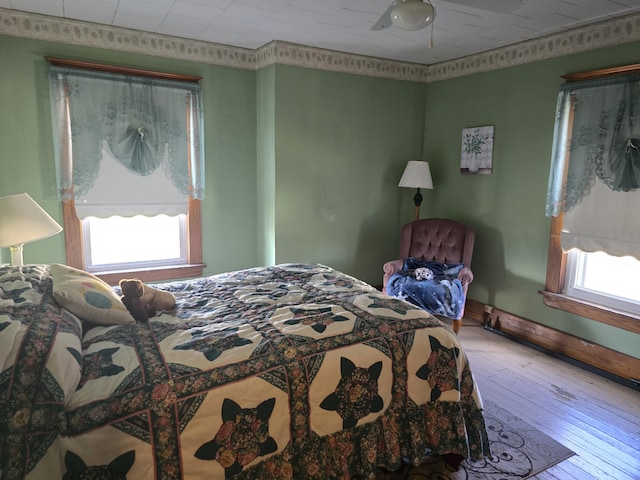 bedroom with hardwood / wood-style flooring and baseboards