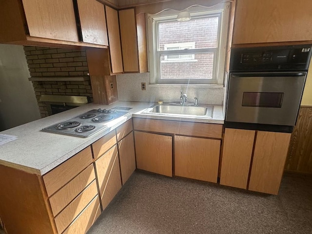 kitchen featuring stainless steel appliances, a peninsula, a sink, and light countertops