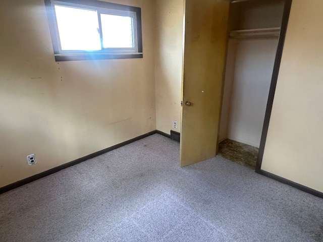 unfurnished bedroom featuring carpet floors, a closet, and baseboards