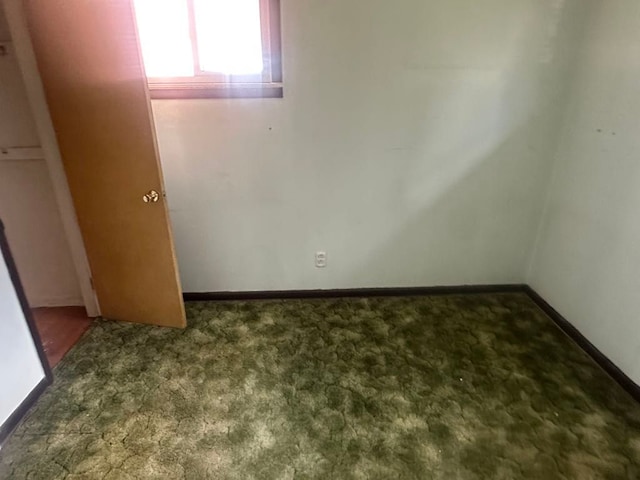 unfurnished bedroom featuring carpet and baseboards